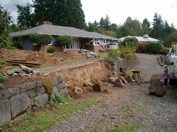 House 9.13.2004 00011.JPG - Basalt is taken apart for the new driveway to be cut in to the detached garage.  The stones will be used to build the walls on the side of the new driveway.